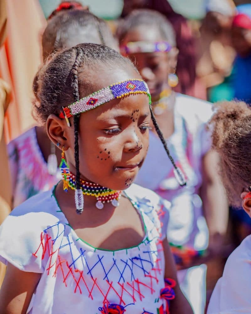 A pupil in beaded headband and embroidered dress during the Cultural Day parade