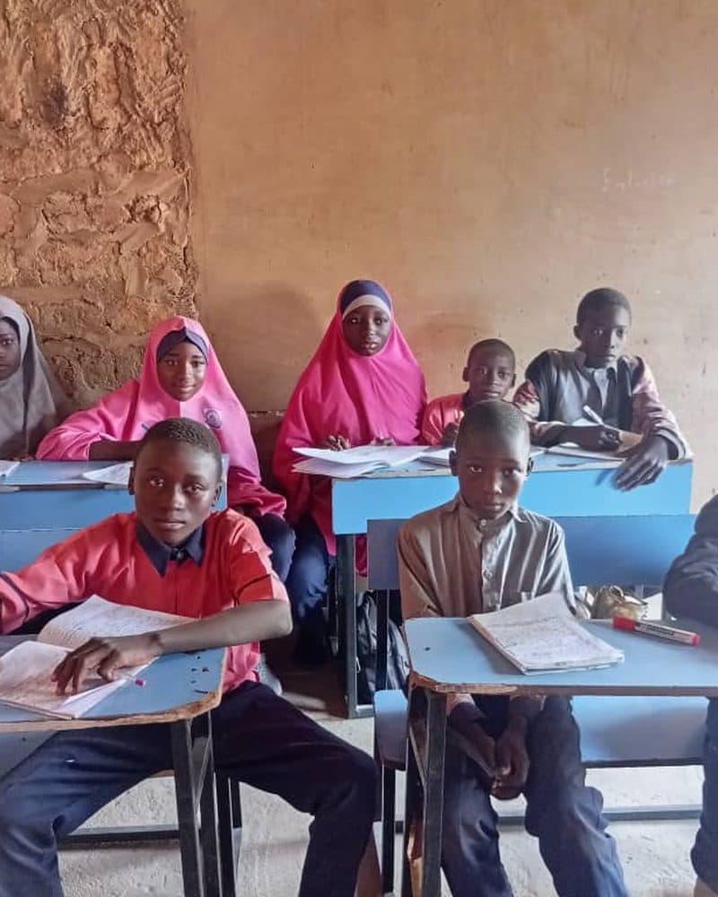 Pupils writing at desks in a classroom